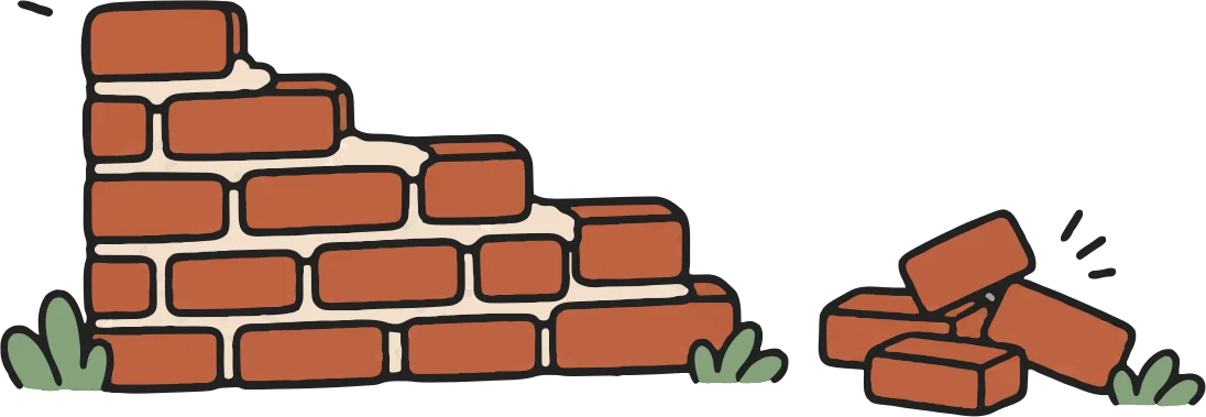 A small pile of clay bricks and a half-built wall